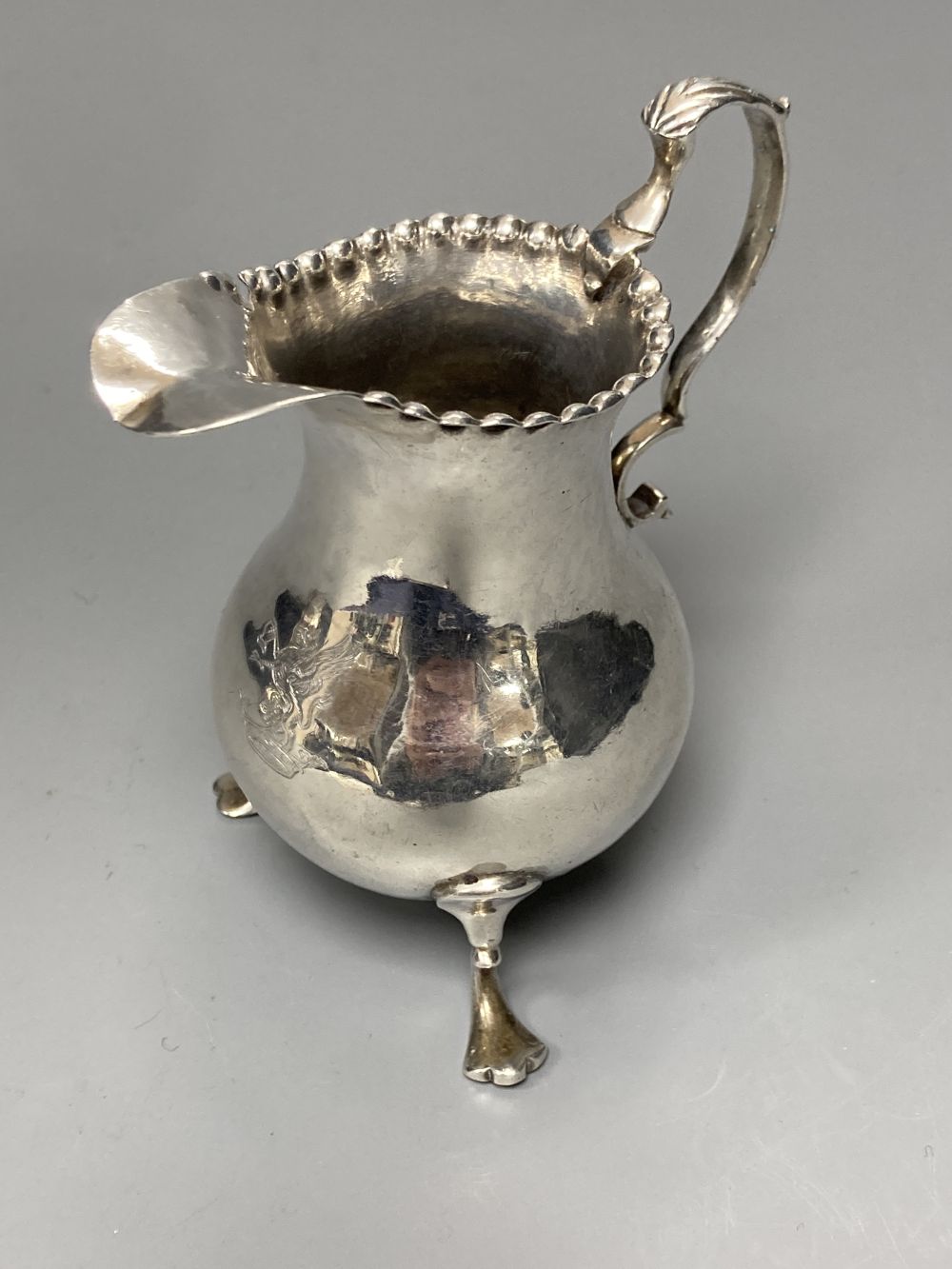 Two 18th century silver cream jugs, London, 1759 & 1768, the former with later embossed decoration,